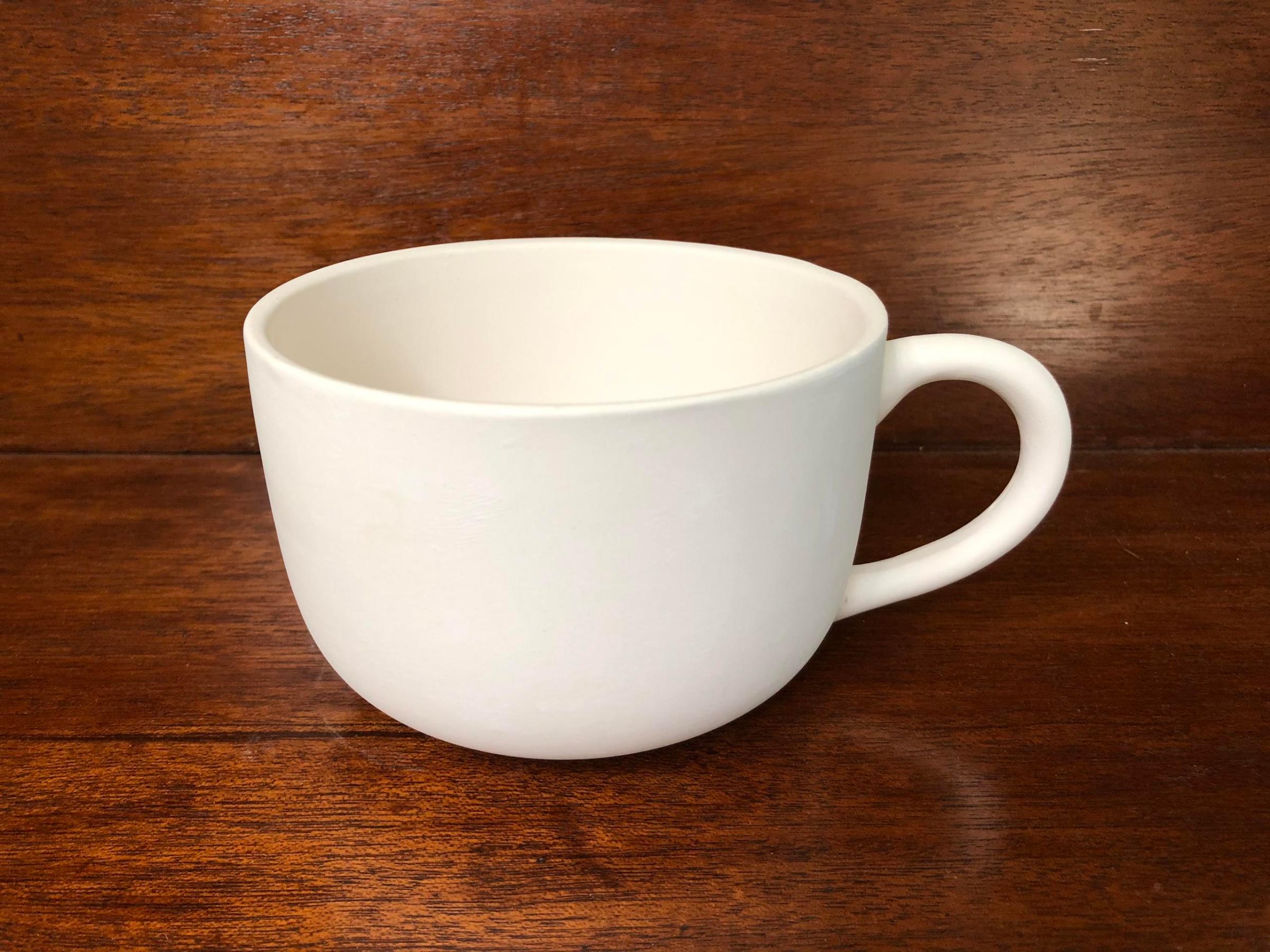 a close up of a coffee cup sitting on top of a wooden table